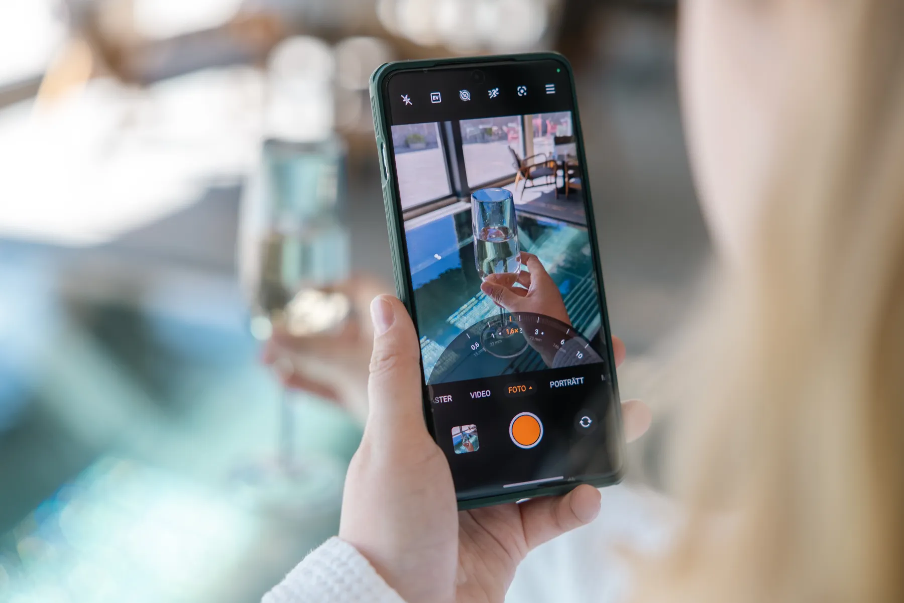 Gäst fotograferar spa-upplevelse med telefon i modern miljö med stora fönster och utsikt mot naturen